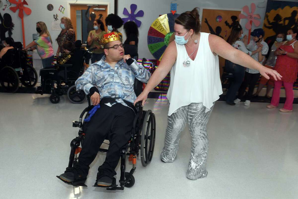 Staff member Colleen Gorman dances with Daniel Thomas during a disco themed prom held for the students at St. Vincent’s Special Needs Services, in Trumbull, May 27, 2022.