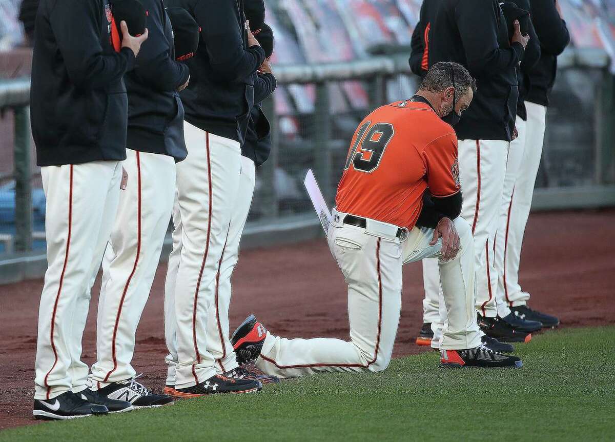 San Francisco Giants manager Gabe Kapler kneels during the national anthem before the San Francisco Giants play the Texas Rangers during MLB game at Oracle Park on Friday, July 31, 2020 in San Francisco, Calif.