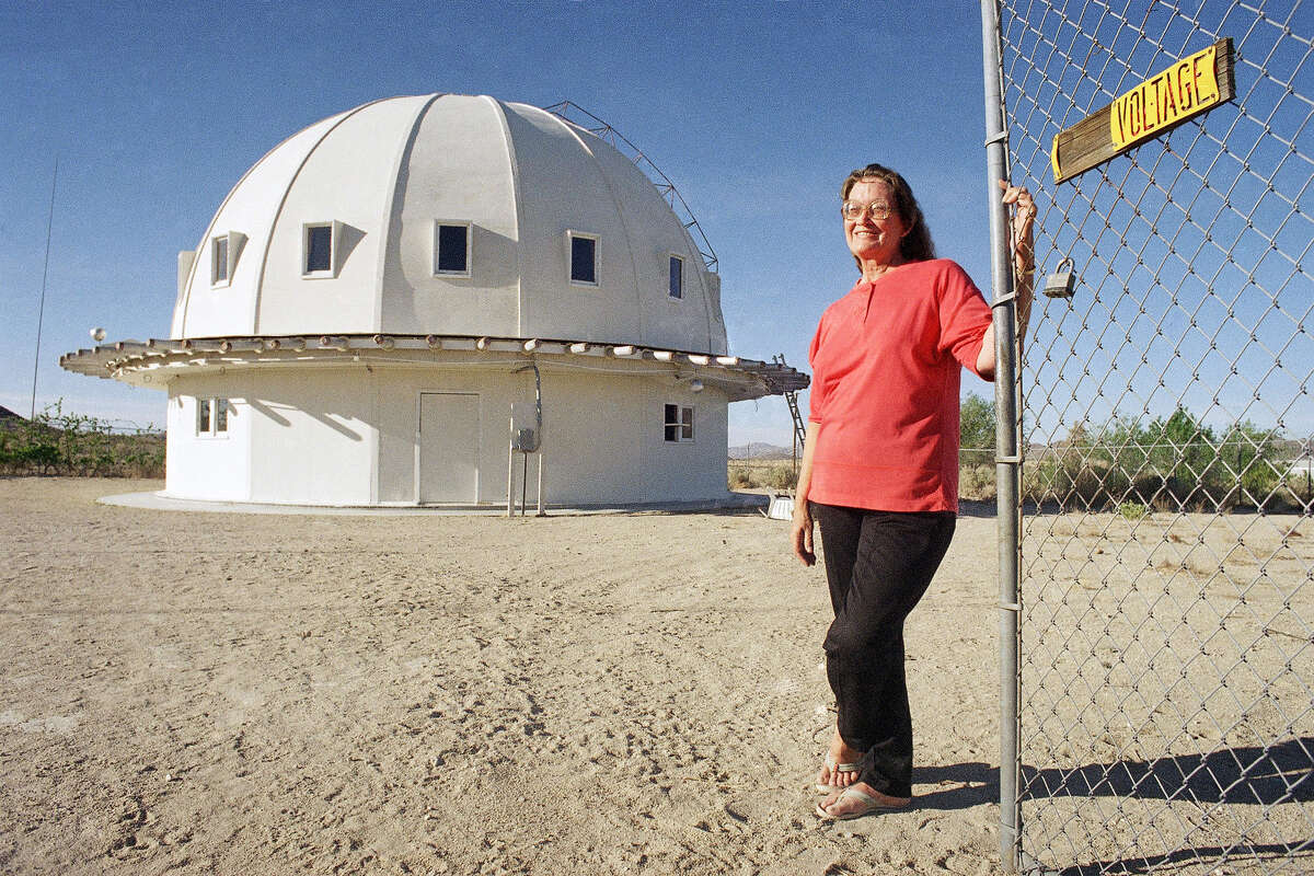 Sandra Boone, daughter of George Van Tassel, builder of the Integratron dome in Landers, Calif., stands at the gated entrance to the site, April 26, 1996. 