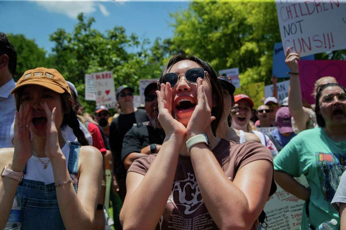Protestors Karen Nguyen, left, and Angel Ly, right, engage in a demonstration at Discovery Green against the presence of the NRA in Houston on Friday, days after the school mass shooting in Uvalde. 
