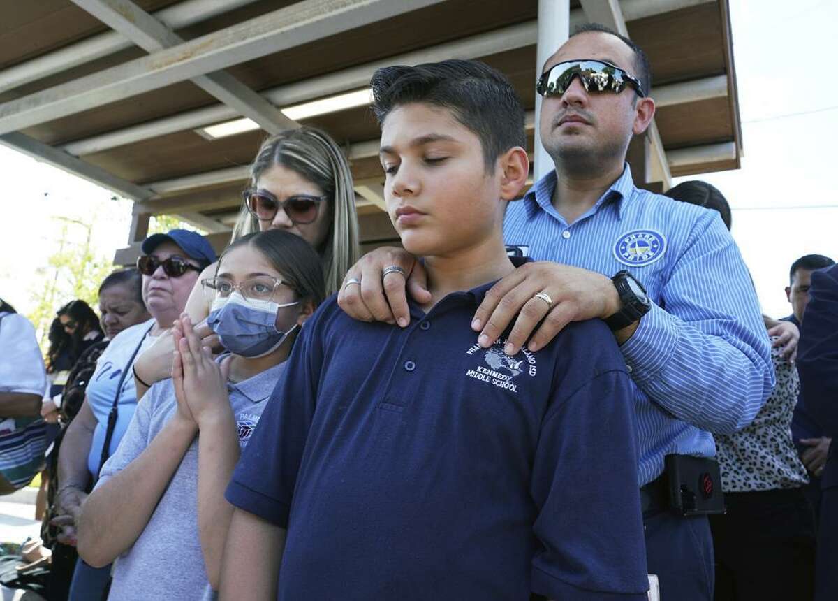 Omahar Padillo holds on to his son Omahar Jr., 12, during a community prayer Wednesday, May 25, 2022, in Pharr, Texas, for the shooting victims at Robb Elementary School in Uvalde, Texas.