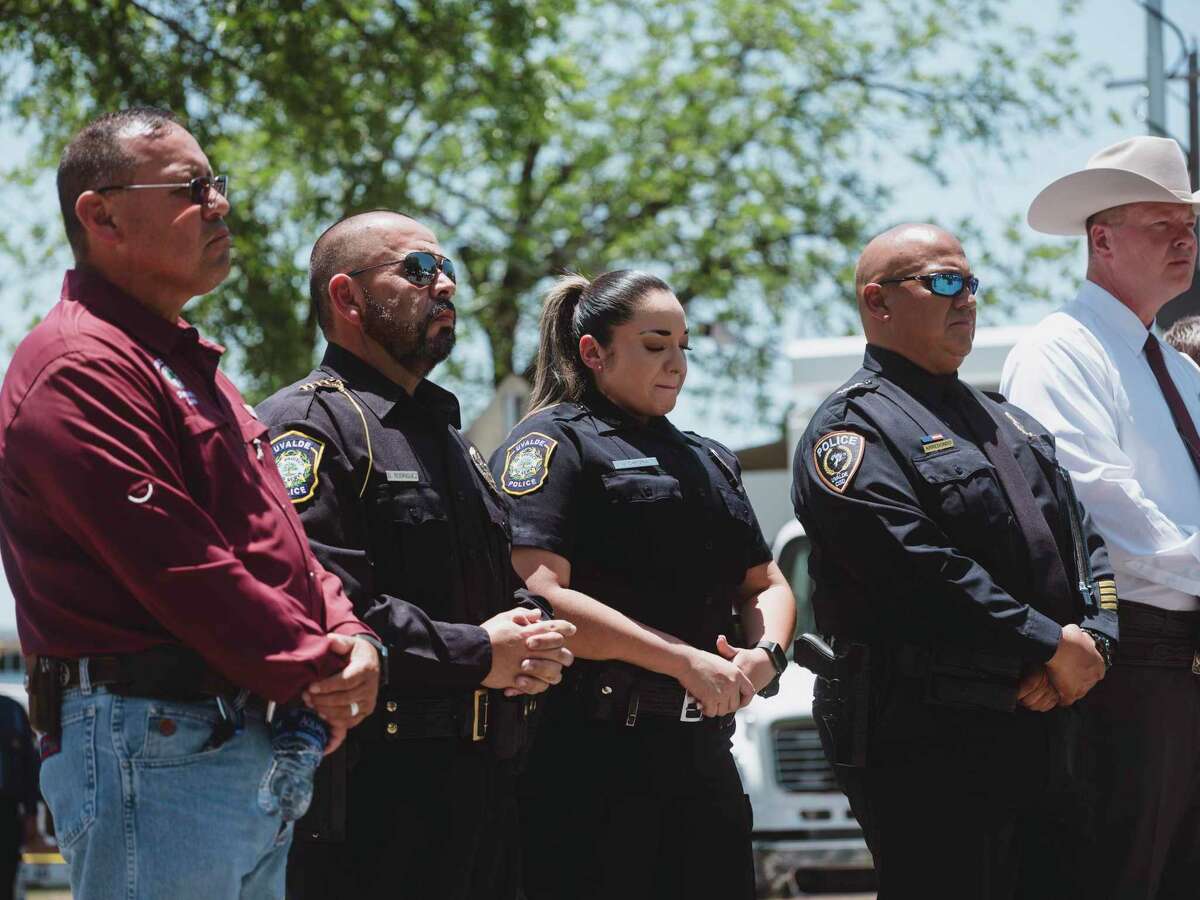 Uvalde Police Department officers, center, listen as Victor Escalon, regional director of the Texas Department of Safety, speaks about the police response timeline to the school shooting at Robb Elementary School in Uvalde. The press conference has only fueled more questions.