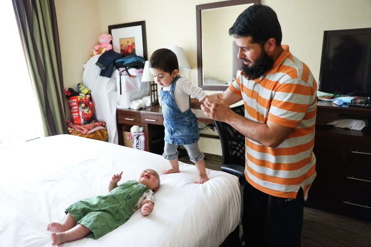 艾哈迈德在特洛克(斯坦尼斯劳斯县)的舒适套房酒店照顾他的孩子，2岁的Sidna和3个月大的Mohammad。他和家人在2021年8月美国撤军期间逃离了阿富汗，在重新安置方面遇到了麻烦。他们已经在旅馆里住了几个月了。