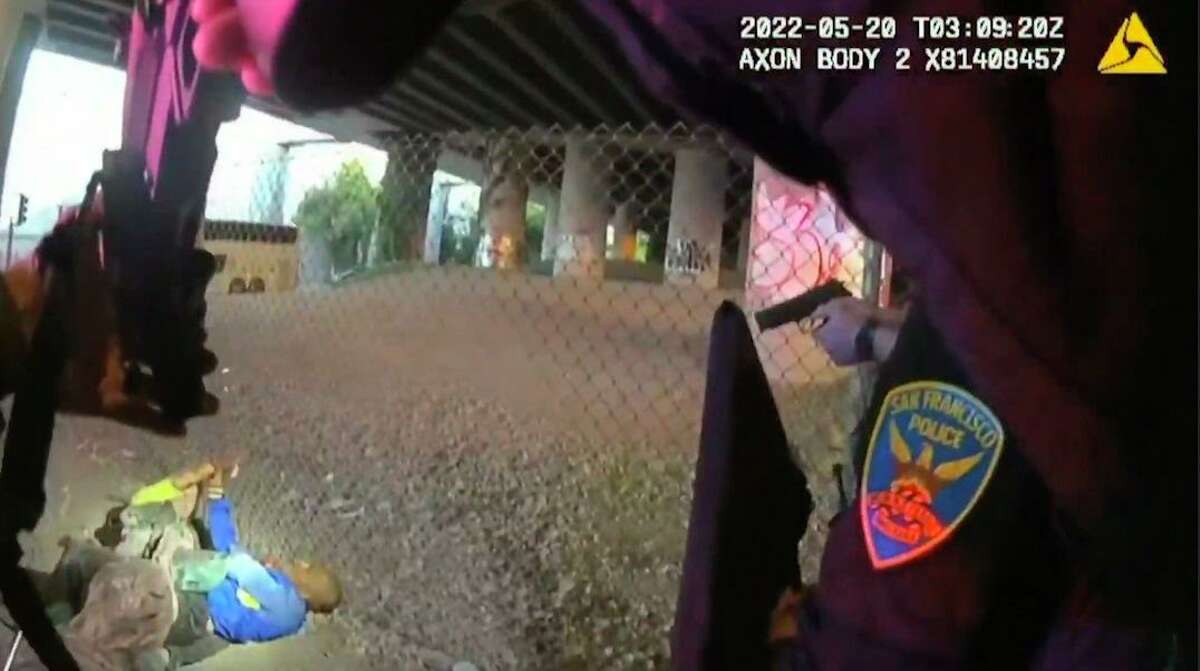 Officers point their guns at two men fighting on the ground in an image from an SFPD body-worn camera. Police killed both men, the footage shows.