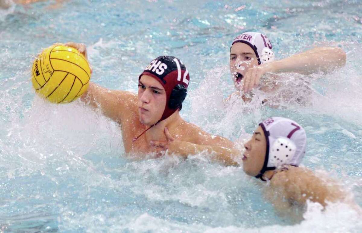 Greenwich High School water polo captain, Matthew Weber, # 12, left, breaks through Phillips Exeter Acdemy defenders Brooks Reavill, # 13 and Jan Shi, # 7, during match against Phillips Exeter Academy at the GHS pool, during the 36th Cardinal Water Polo Tournament, Saturday afternoon, Oct. 2, 2010.