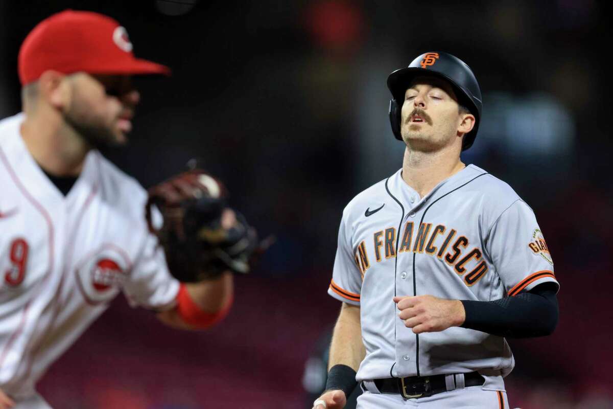 San Francisco Giants' Mike Yastrzemski, right, reacts as he is caught in a double play while attempting to return to first base during the sixth inning of a baseball game against the Cincinnati Reds in Cincinnati, Friday, May 27, 2022. (AP Photo/Aaron Doster)