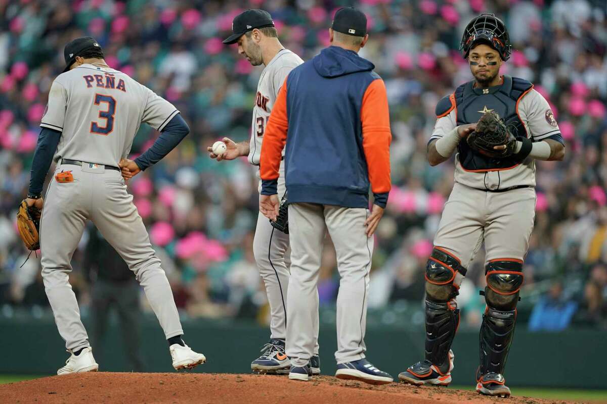 Houston Astros starting pitcher Justin Verlander, second from left, talks with pitching coach Joshua Miller, second from right, Jeremy Pena (3) and Martin Maldonado, right, during a mound conference in the sixth inning of the team's baseball game against the Seattle Mariners, Friday, May 27, 2022, in Seattle. (AP Photo/Ted S. Warren)