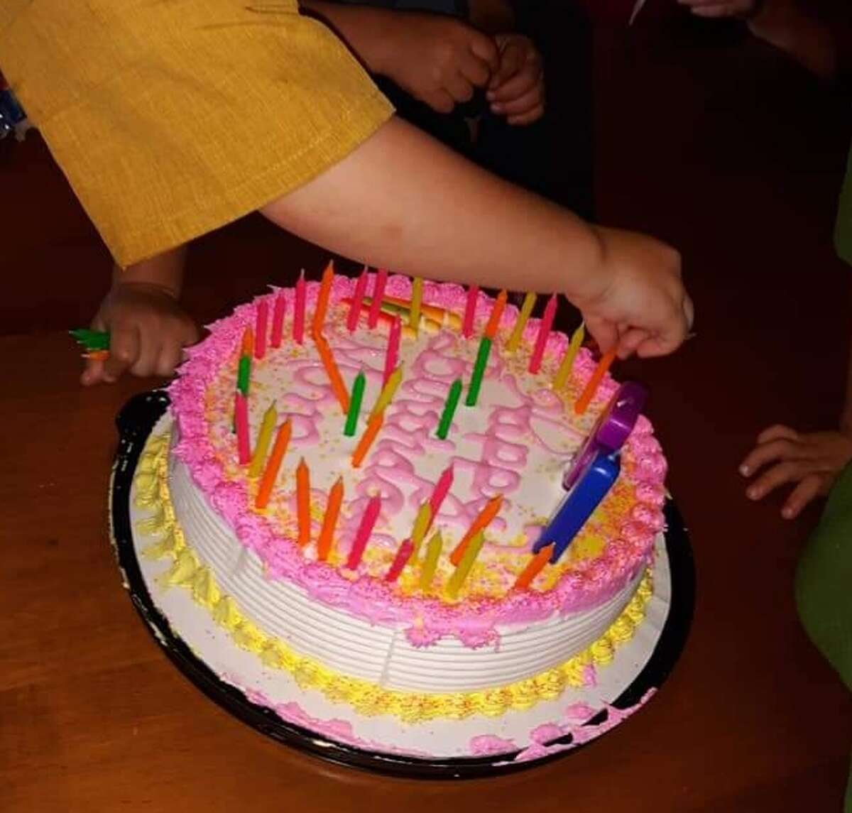 Lovina's grandchildren work on adding 51 candles to her birthday cake.