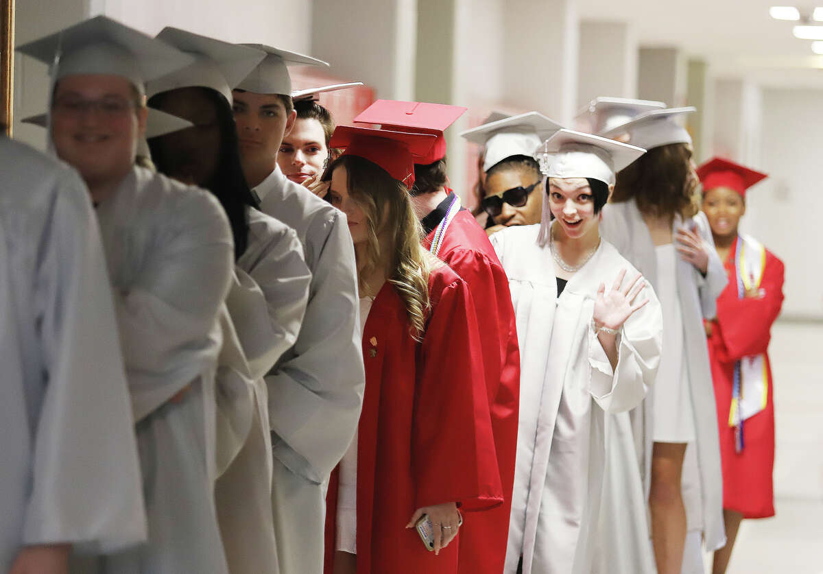 An Alton High School senior waves as students line up for graduation Friday night. The self-described "most adaptive class" ever at AHS said they were stronger because of the COVID-19 challenges they overcame.