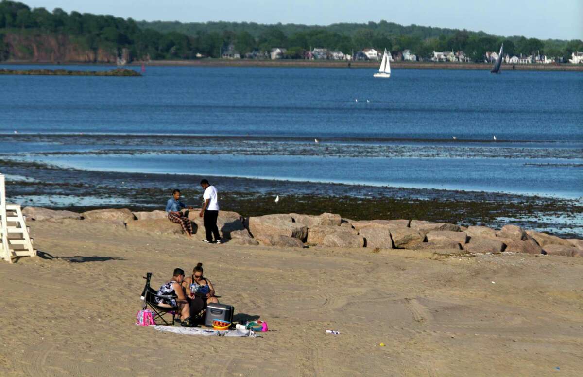 Several residents enjoy the beach in West Haven, Conn., on Thursday May 27, 2021. Only cars with town beach stickers can park on the streets off Beach Street, helping to keep out-of-towners from parking there.