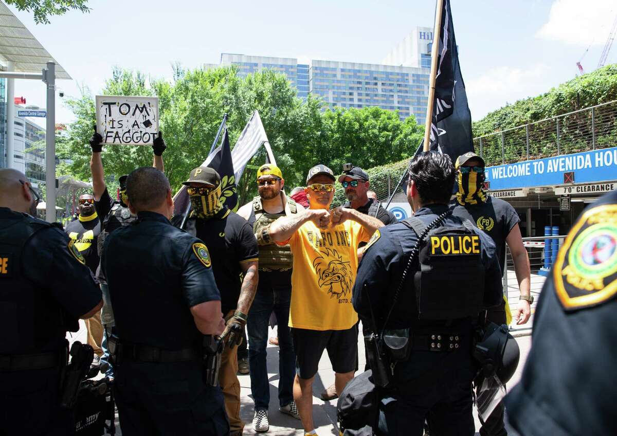 Proud Boys members show up at a group of people protesting against the NRA convention taking place at the George R. Brown Convention Center Saturday, May 28, 2022, at Discovery Green in Houston. Houston Police officers asked the group to stay on the opposite side of the parking garage.