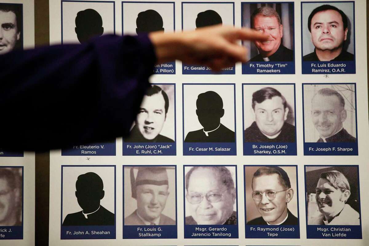 In this 2018 file photo, a sexual abuse victim points to the photos of Catholic priests accused of sexual misconduct by victims during a news conference in Orange, Calif.