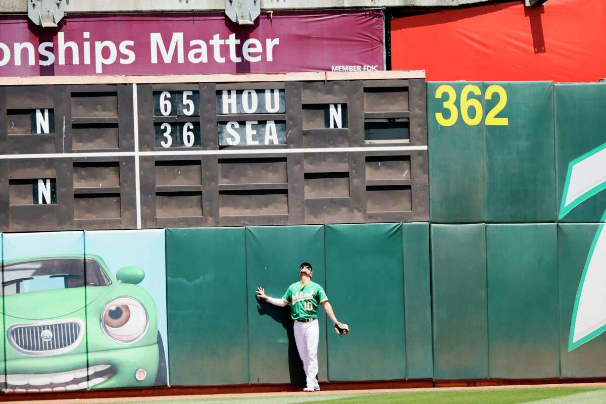 Oakland Athletics left fielder Chad Pinder (10) watches a ball go over his head for a Texas Rangers homer in the third inning of an MLB game at RingCentral Coliseum, Saturday, May 28, 2022, in Oakland, Calif.