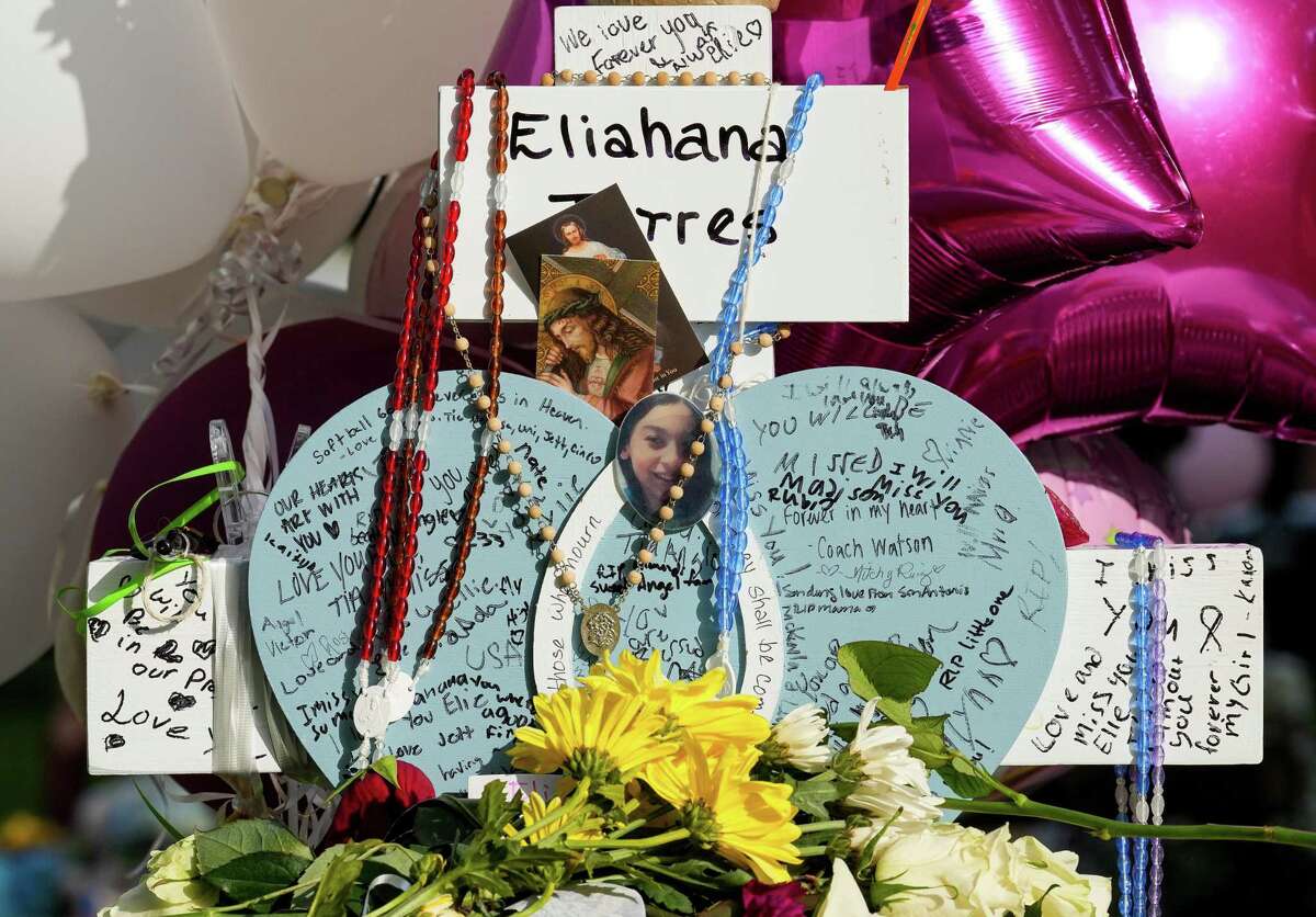 A cross for Eliahna Torres, is engulfed with flowers, toys, balloons, candles and written messages at the Town Square, where a memorial for the victims of the mass shooting at Robb Elementary School is located, on Saturday, May 28, 2022, in Uvalde.