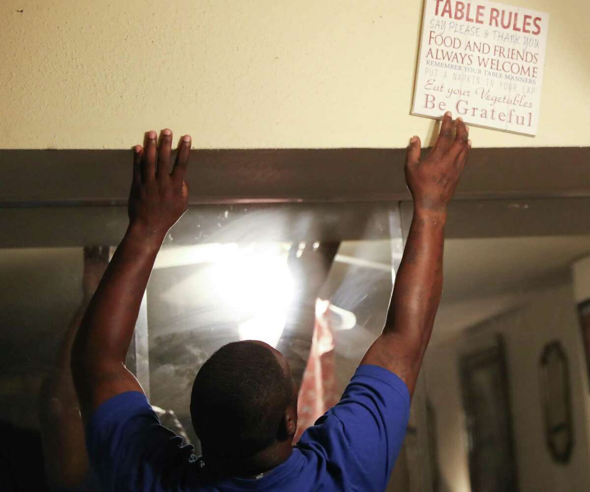 Dorran Gillespie removes a sign in the dining room as he packs up his home on Thursday, May 12, 2022 in Houston. The two thought they found the perfect home for their family in December, but after putting down the deposit and getting the keys, found out that the home was not available. They hastily rented an apartment that was in need of repairs, which they’ve tried to get the landlord to fix, but are now being evicted.