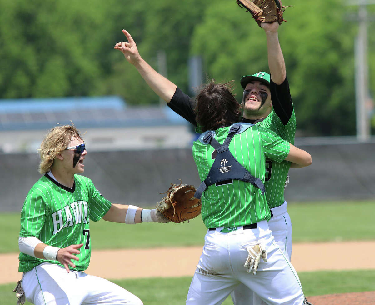 Carrollton catcher Kyle Leonard embraces pitcher Grant Pohlman while third baseman Lucas Howard rushes in to join the celebration after the final out of the Hawks' championship victory over Centralia CORL on Saturday in the Greenville Class 1A Sectional at Greenville University.