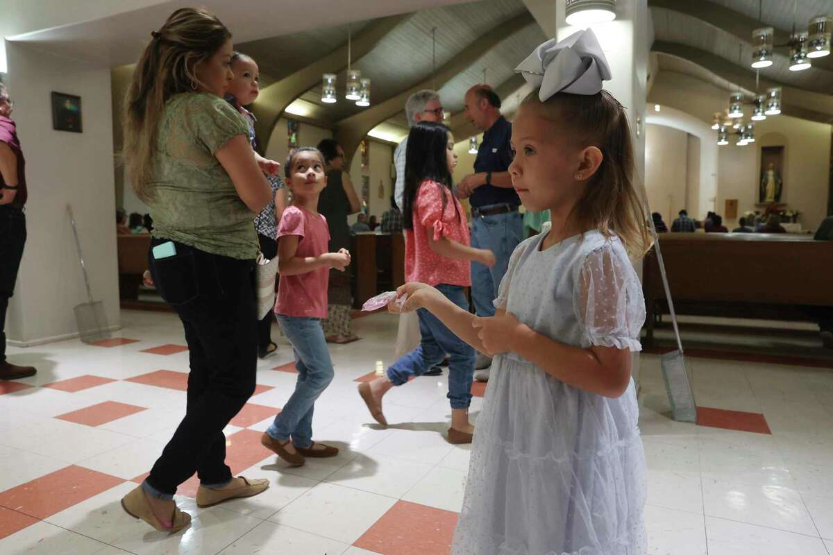 Four-year-old Layna Freitag hands out rosaries before a service at Sacred Heart Church in Uvalde, Texas, Sunday, May 29, 2022.