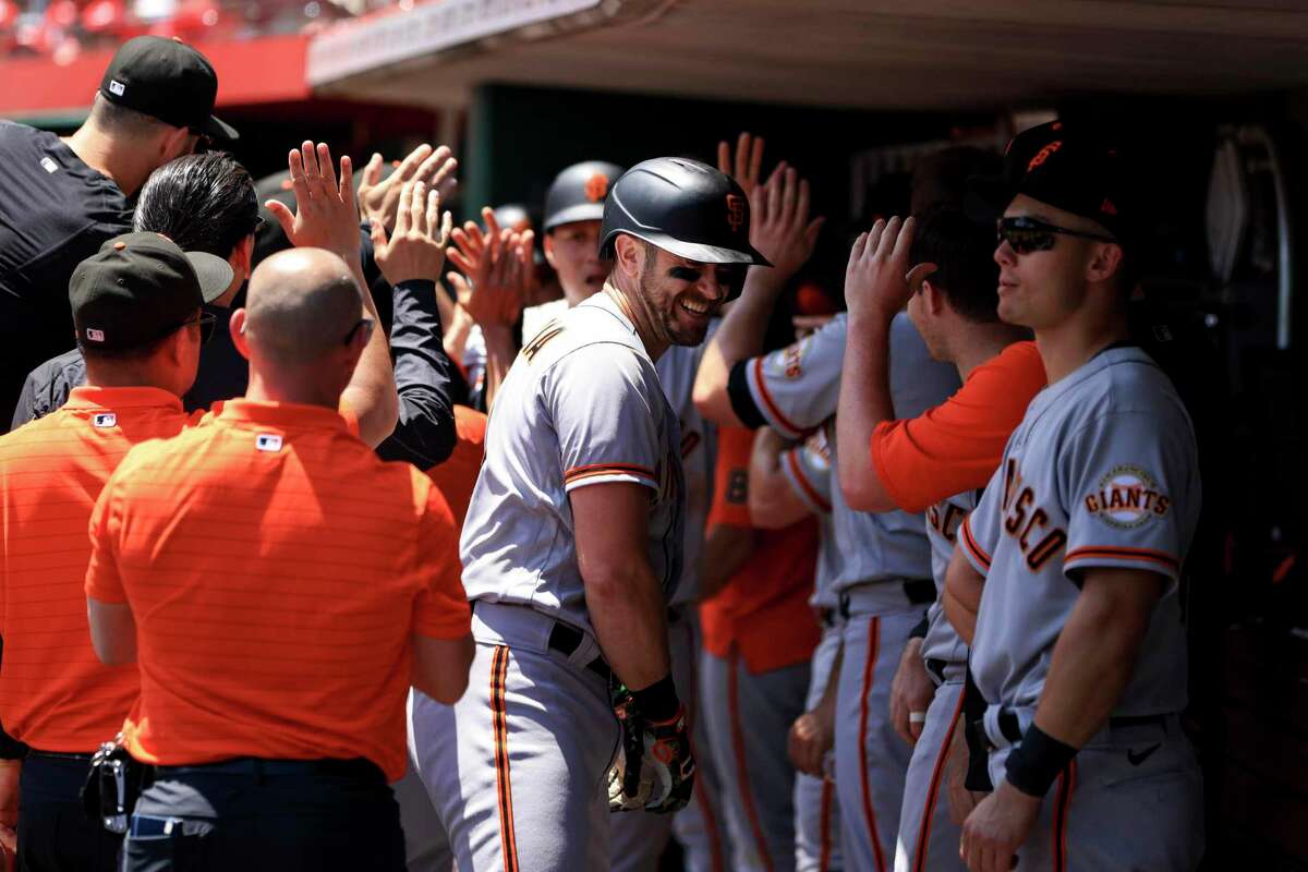 Evan Longoria (center) celebrates in the dugout with the rest of the team after hitting a three-run home run to give the Giants the lead in the eighth inning.