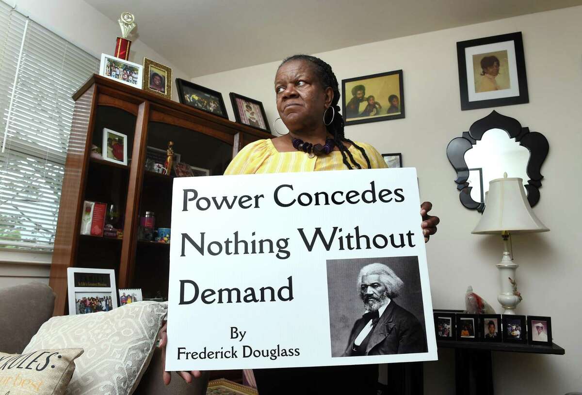Community activist Barbara Fair is photographed in her home in West Haven on May 19, 2022 holding a sign with her favorite quote by Frederick Douglass.