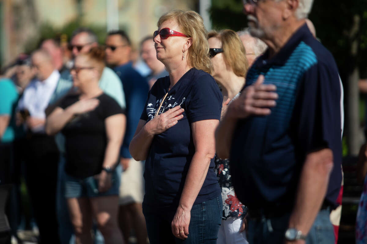 Marsha Stamas holds her hand to her heart during the Pledge of Allegiance as community leaders, veterans and area residents gather for a presentation of wreaths in honor of Memorial Day at the Midland County Veterans Memorial Monday, May 30, 2022.