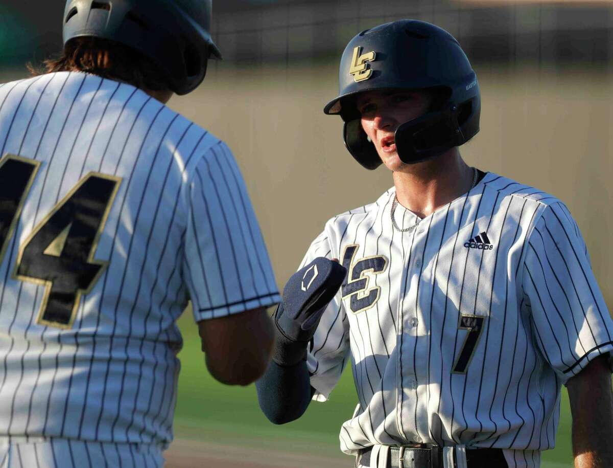 Lake Creek’s Blake Brown, right, gets a high-five from Aiden Delacerda after scoring on Luke Ekdall’s RBI double in the second inning of Game 2 of a Region III-5A semifinal high school baseball playoff series at Langham Creek High School, Friday, May 27, 2022, in Cypress.