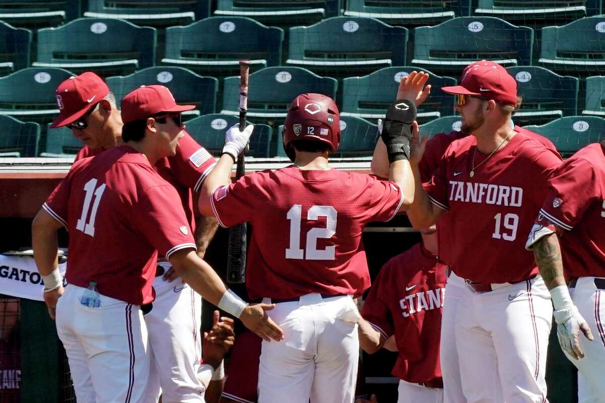 Stanford's Tommy Troy (12) is congratulated by Alberto Rios (11) and Henry Gargus (19) after scoring against Arizona State during the fifth inning of a first-round Pac-12 tournament game Wednesday in Scottsdale, Ariz.