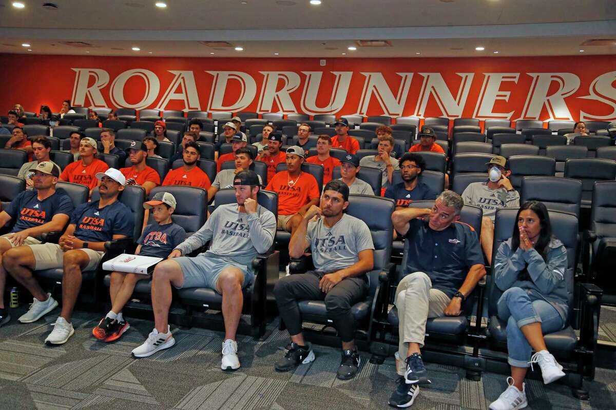 UTSA baseball coach Patrick Hallmark, second from right, and athletic director Lisa Campos watch the NCAA Tournament selection show on Monday with the rest of the team.