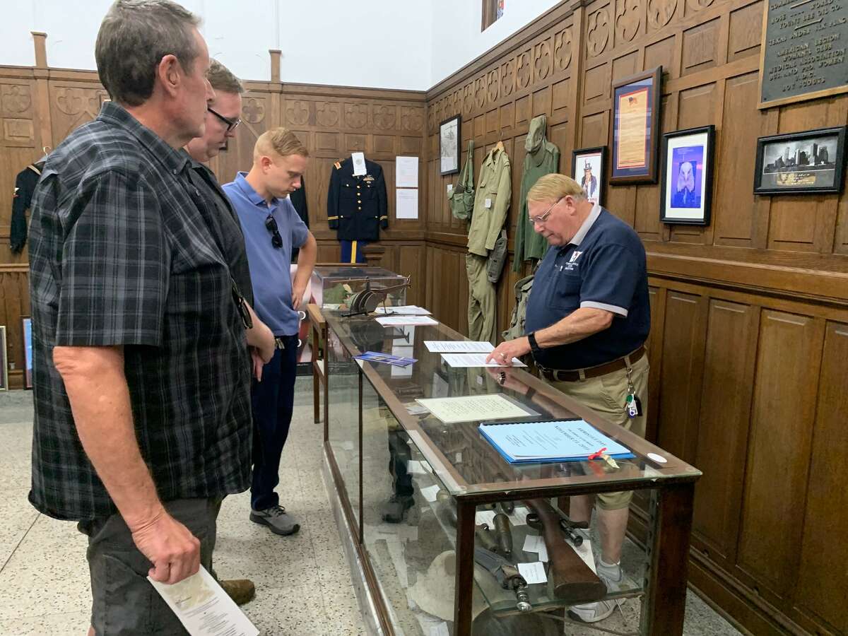 Lamar Institute of Technology instructor Dennis White, right, shows visitors artifacts donated to the Temple to the Brave museum for Memorial Day. Photo taken May 30, 2022. Photo by Olivia Malick/The Enterprise.