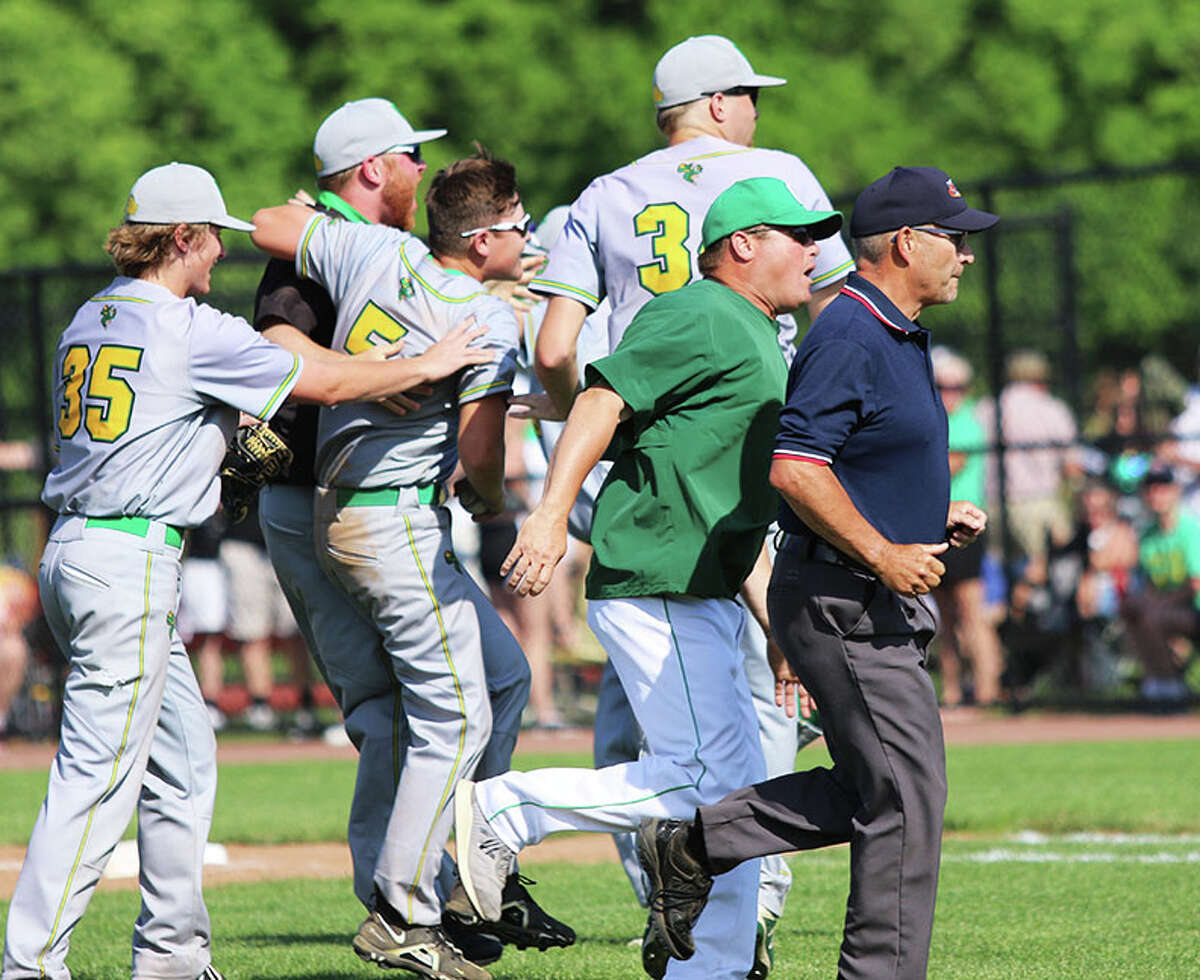 While Brown County players celebrate on the field, Carrollton coach Ryan Howard pursues the umpire running off the field after making a runner's interference call to end the game Monday in the Springfield Class 1A Super-Sectional at Lincoln Land Community College.