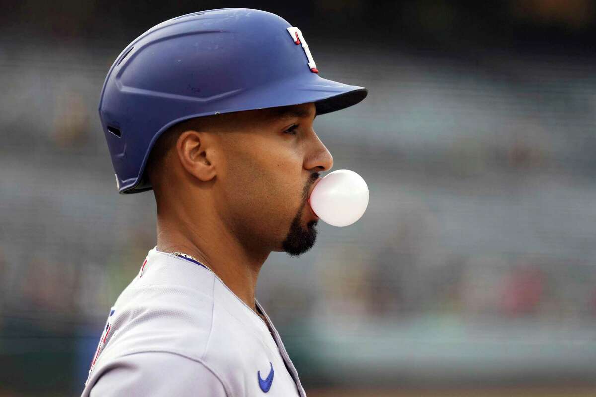 Texas Rangers' Marcus Semien blows a bubble in the on-deck circle during the second inning of a baseball game against the Oakland Athletics Thursday, May 26, 2022, in Oakland, Calif.