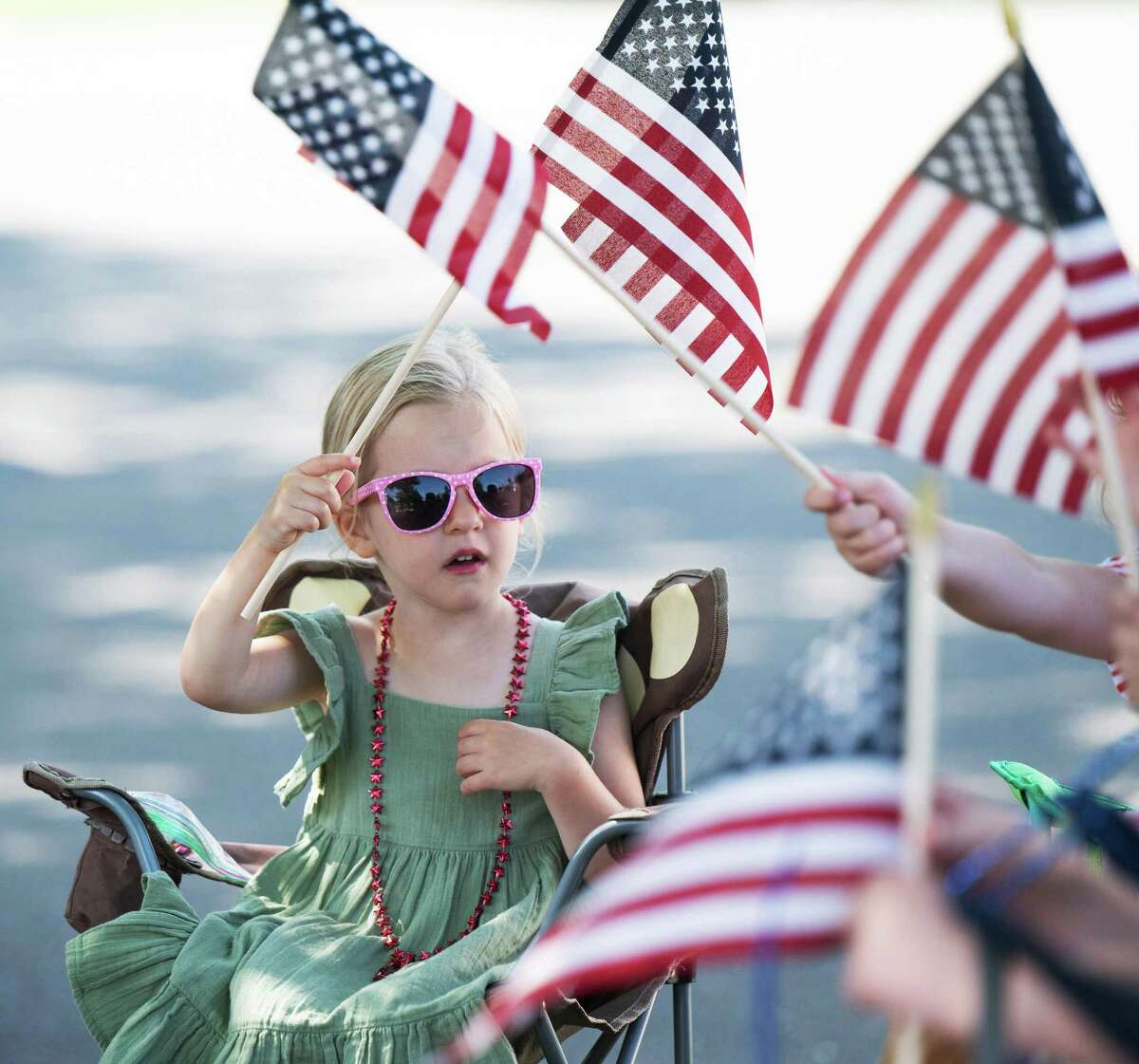 3-year-old Devyn Kurtz waves a flag with friends and family at Memorial Day parade on Monday, May 30, 2022 in Wilton, Connecticut.