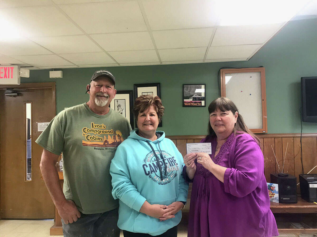 Dave and Kelly Wieda, of Ivan's Campground and Cabins, present St. Ann's Senior Center Director Shelly Sahfer, right, with a check to go toward the senior meal program. 