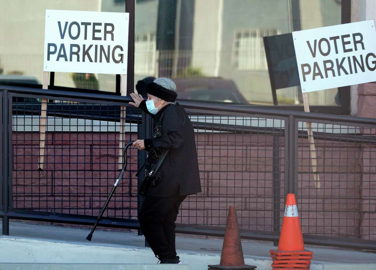 A woman leaves an early voting poll site, Monday, Feb. 14, 2022, in San Antonio. Early voting in Texas began Monday. (AP Photo/Eric Gay)