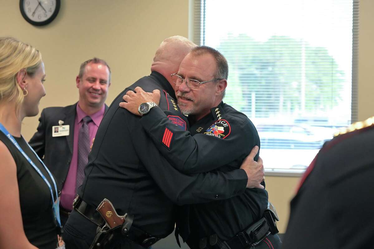 Klein ISD Police Chief David Kimberly, right, gets a congratulatory hug from Harris County Precinct 4 Constable Mark Herman during Kimberly's retirement party.