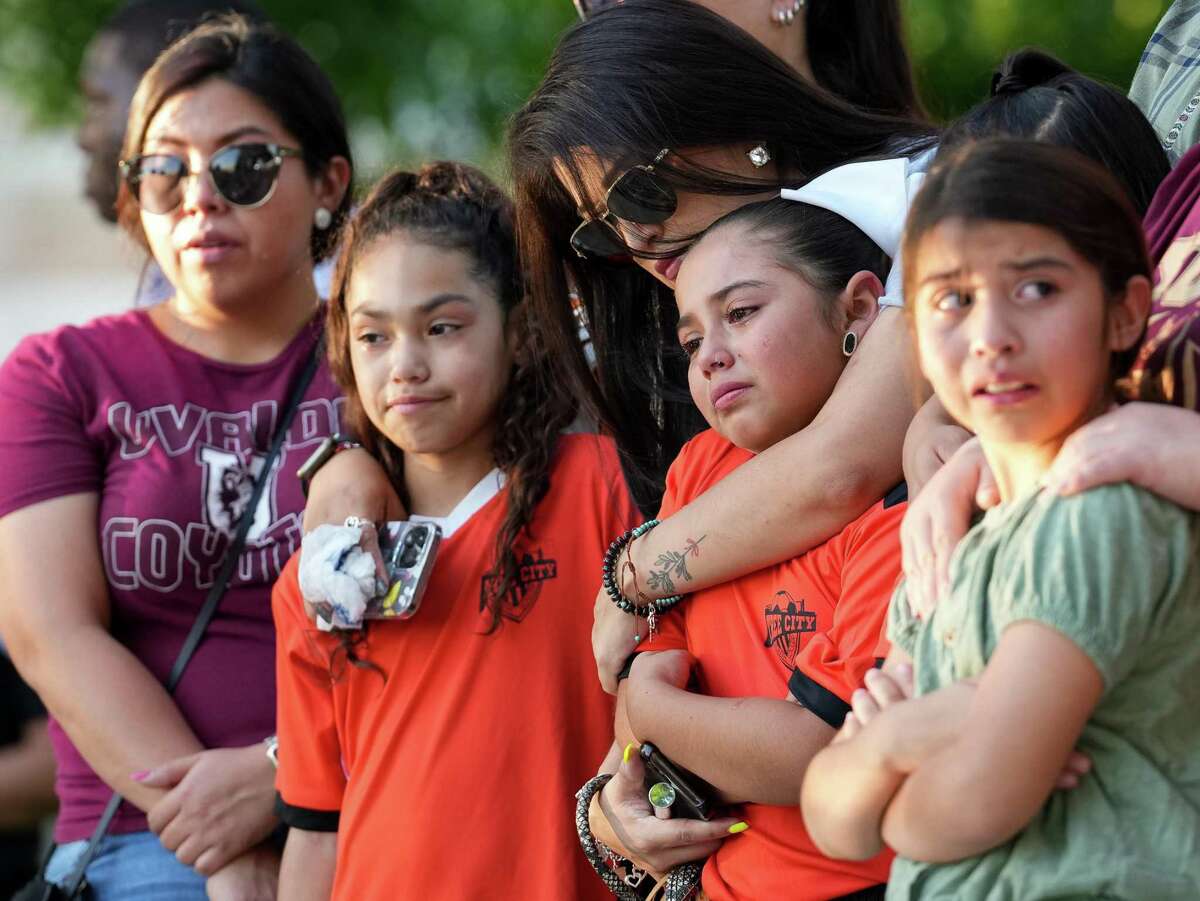 A group of girls grieves as they visit the memorial for the victims of the Robb Elementary School mass shooting at the city’s Town Square on Thursday, May 26, 2022, in Uvalde, Texas. Nineteen children and two adults were killed by the 18-year-old gunman.