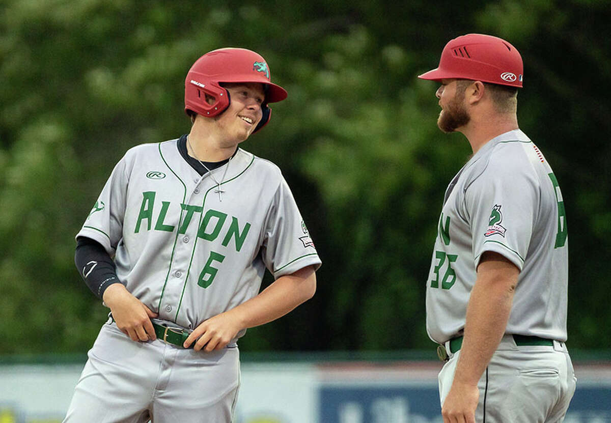 Adam Stilts of the River Dragons, left, talks with a team coach after reaching first base in a game last season. Stilts will be the starting pitcher in Wednesday's season opener against Springfield at Hopkins Field in Gordon Moore Park.