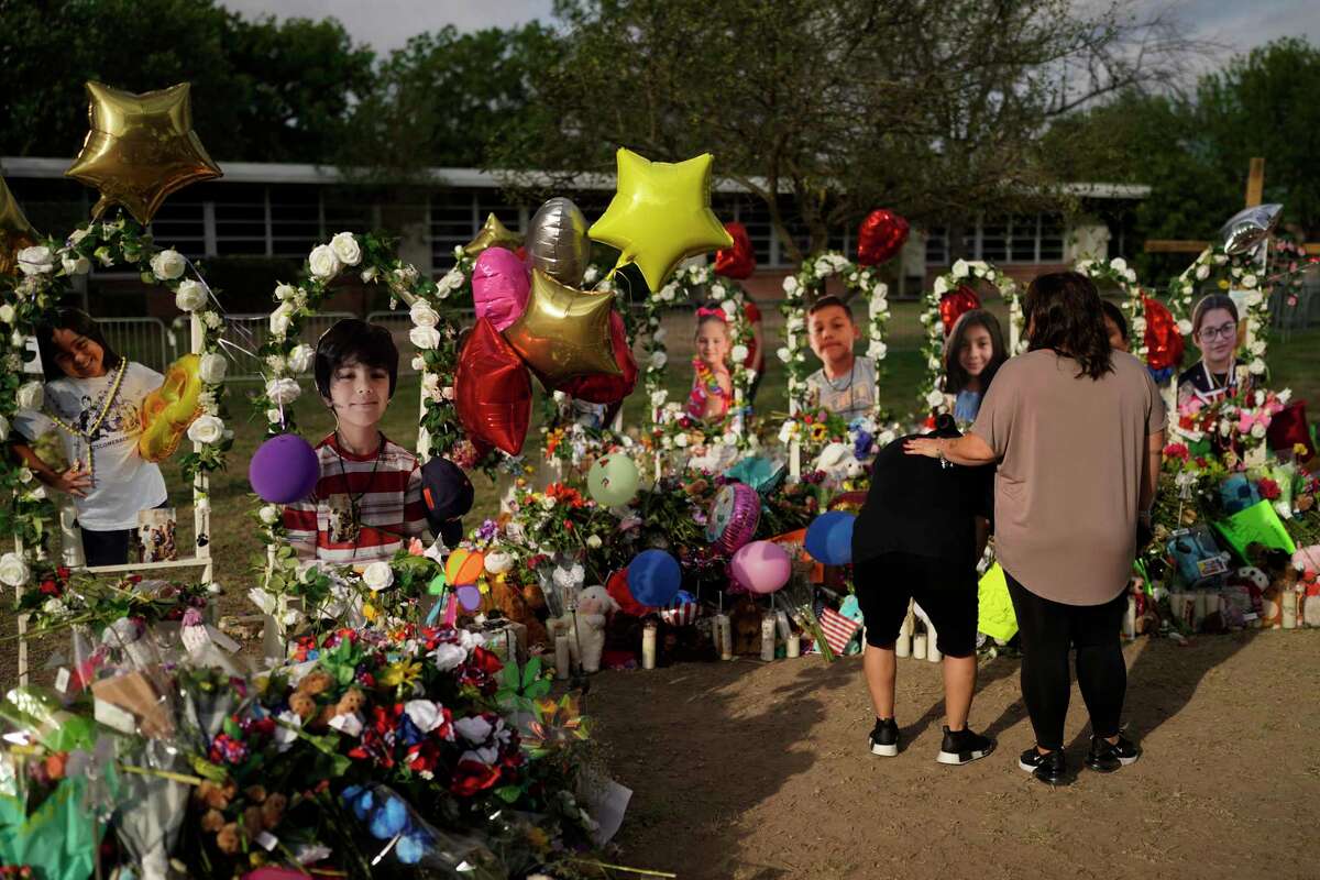 Jolean Olvedo, left, weeps while being comforted by her partner Natalia Gutierrez at a memorial for Robb Elementary School students and teachers killed in a recent school shooting in Uvalde, Texas.