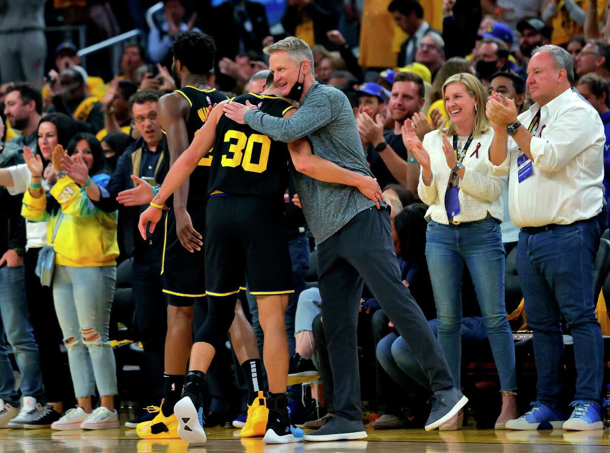Warriors head coach Steve Kerr hugs Stephen Curry (30) as he is subbed out late in the fourth quarter as the Golden State Warriors defeated the Dallas Mavericks 120-110 in Game 5 of the Western Conference Finals to advance to the NBA Finals at Chase Center in San Francisco, Calif., on Thursday, May 26, 2022.