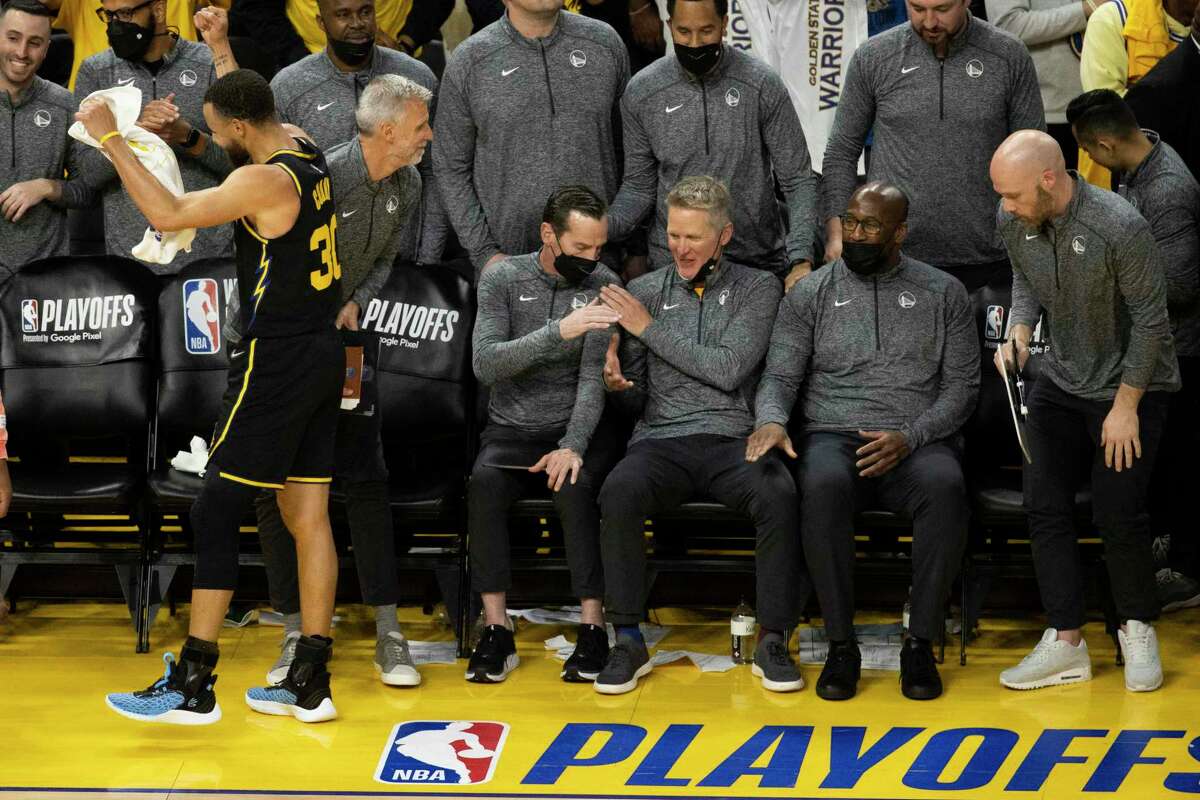 Golden State Warriors Head Coach Steve Kerr congratulates assistant coach Kenny Atkinson in the closing minutes in Game 5 of the NBA basketball playoffs Western Conference finals against the Dallas Mavericks in San Francisco, Calif. Thursday, May 26, 2022.