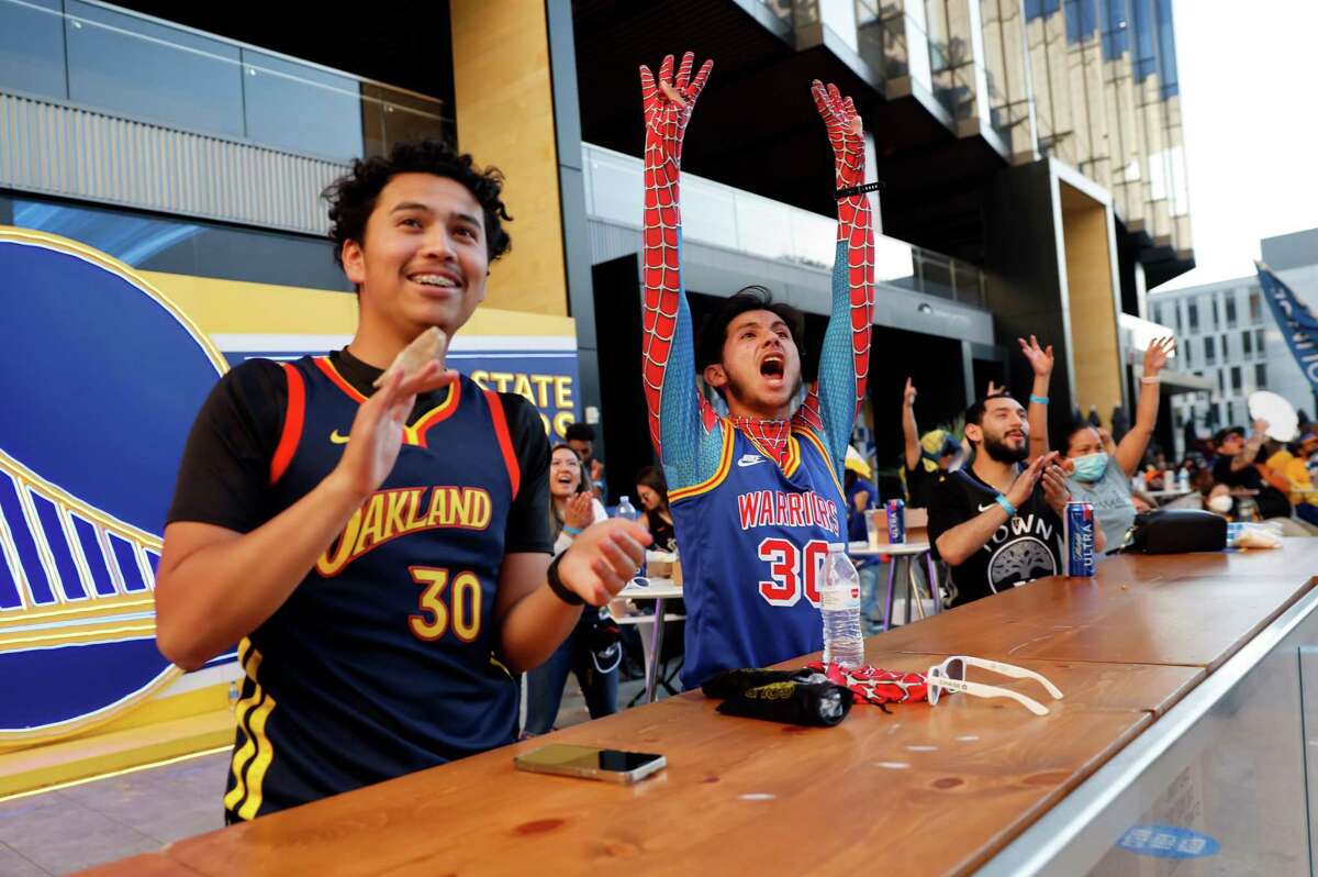 Raul Valencia and Armando Ramirez react to Klay Thompson (11) scoring a three point shot as fans watched the Golden State Warriors play the Dallas Mavericks in Game 4 of the NBA Playoffs Western Conference Finals during a watch party at Chase Center in San Francisco, Calif., on Tuesday, May 24, 2022.