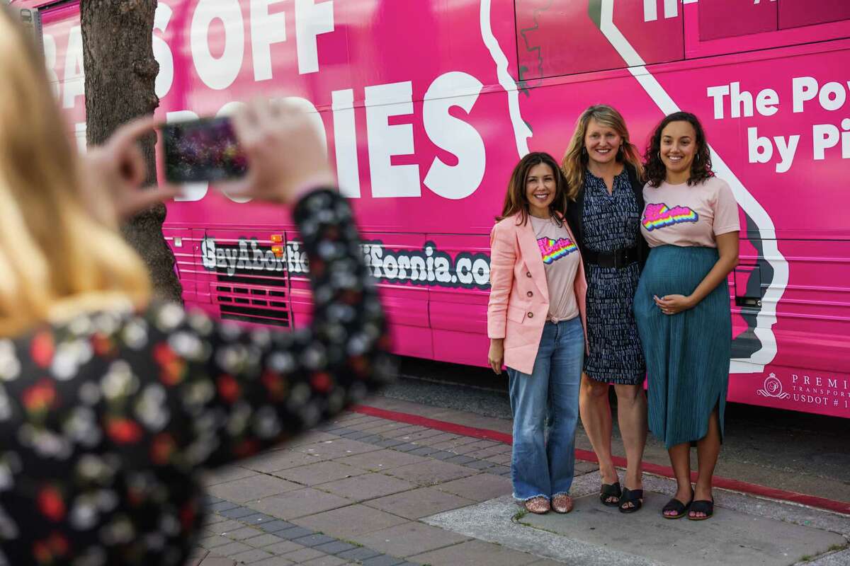 (L-r) Jodi Hicks, President and CEO of Planned Parenthood Affiliates of California, Assemblymember Buffy Wicks, and Jessica Pinckney, the Executive Director of Access Reproductive Justice pose in front of the pink bus which is taking a tour around the state in Oakland, California on Thursday, May 19, 2022.