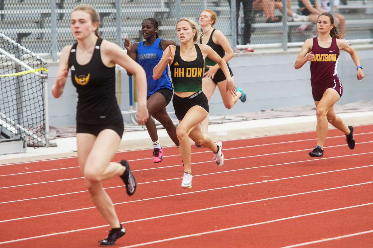 Dow High's Emma Thomas (center) competes in the 400-meter dash during a May 20, 2022 regional at Midland Stadium.
