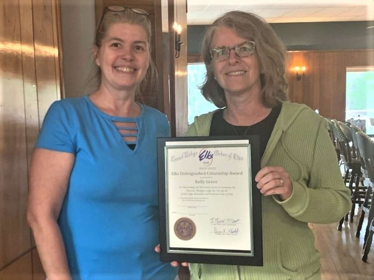 Kelly Greve, head of the volunteer group Manistee Proud (right), receives the Elks Lodge No. 225 2021-22 Distinguished Citizenship Award from Julie Waruszewski, bar manager of the Elks Lodge.