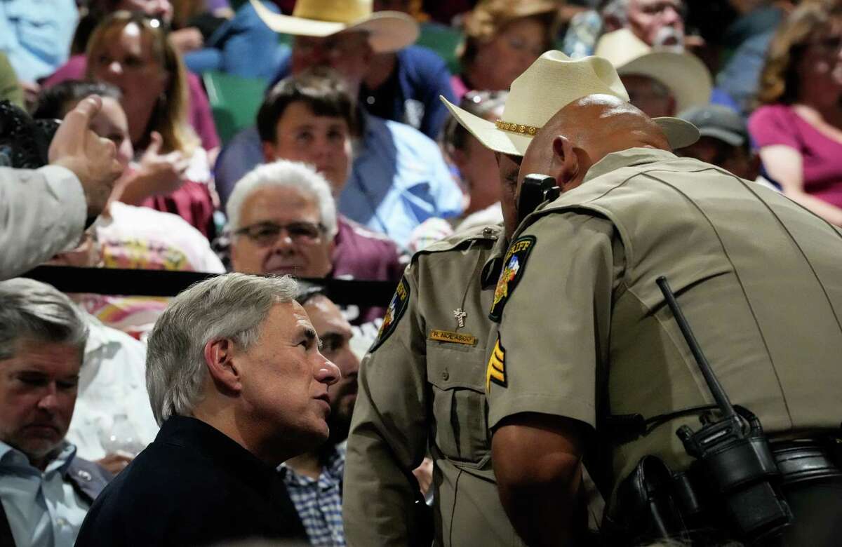 Gov. Greg Abbott talks with Uvalde County Sheriff Ruben Nolasco and a deputy before a prayer vigil for victims of the mass shooting at Robb Elementary School on Wednesday, May 25, 2022, at the Uvalde County Arena in Uvalde.