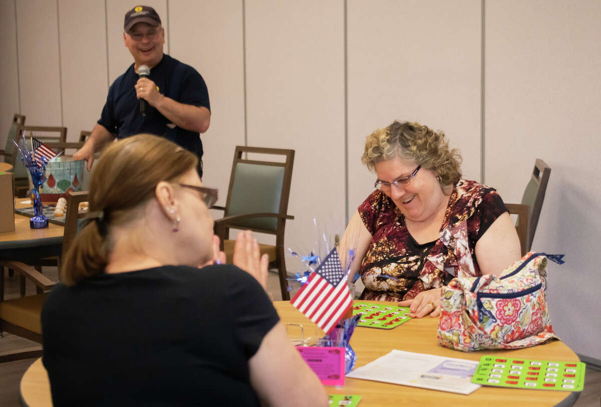 Cherie Smith, right, smiles after calling out "bingo" during a game led by Scott Tefft, left, Wednesday, June 1, 2022 at Trailside Activity and Dining Center in Midland.
