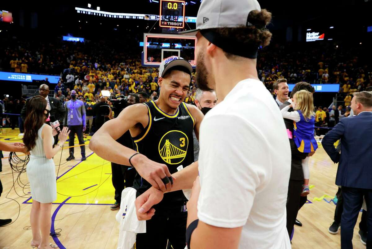 Jordan Poole (left) comes in for a hug from Klay Thompson after the Golden State Warriors defeated the Dallas Mavericks 120-110 in Game 5 of the Western Conference Finals to advance to the NBA Finals at Chase Center in San Francisco, Calif., on Thursday, May 26, 2022.