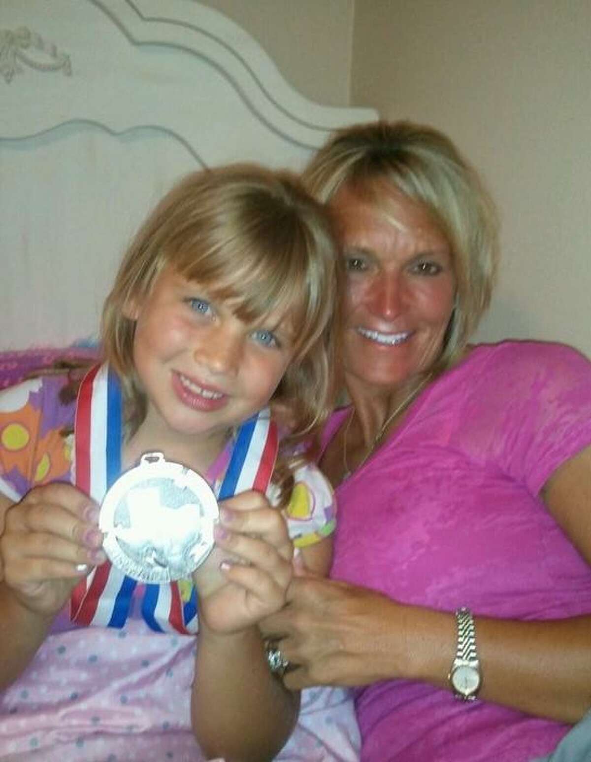 In 2012, Michelle Rochinski and her daughter Kalee pose for a photo with the silver medal Michelle received after the Montgomery Bears were runner-up in the UIL Class 4A championship.