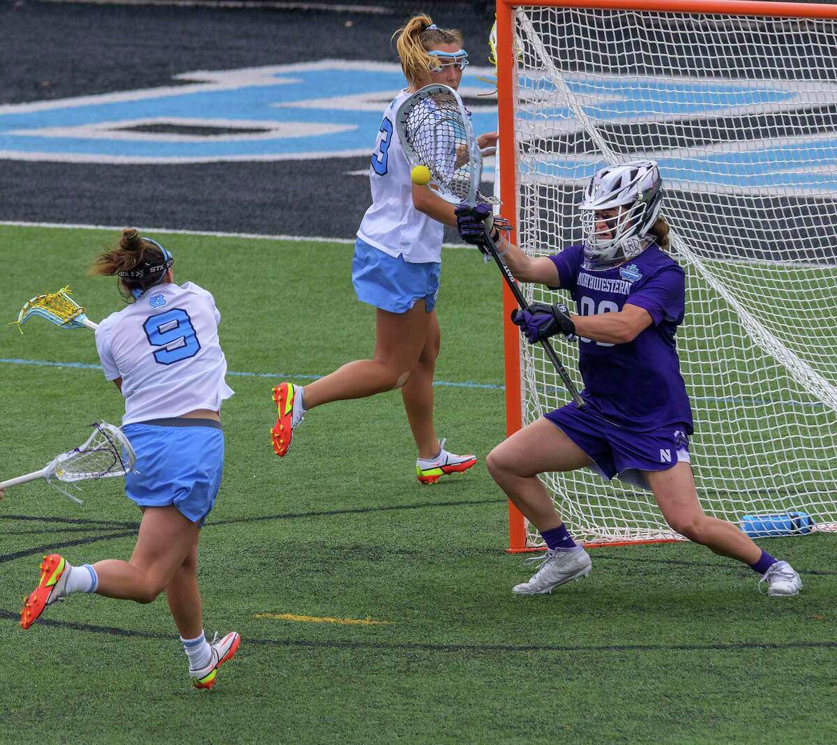 Northwestern goalkeeper Madison Doucette (99) blocks a shot by North Carolina midfielder Nicole Humphrey (9) during the semifinals of the NCAA Division I women's lacrosse tournament at Homewood Field, Friday, May 27, 2022, in Baltimore. (Karl Merton Ferron/The Baltimore Sun via AP)