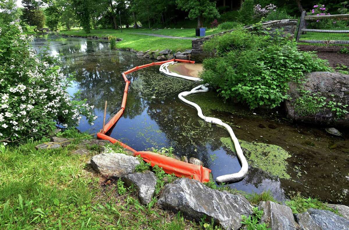 After an oil spill last week, orange "booms" sit on the surface of the water at Binney Park in Greenwich, Conn., on Tuesday May 31, 2022.