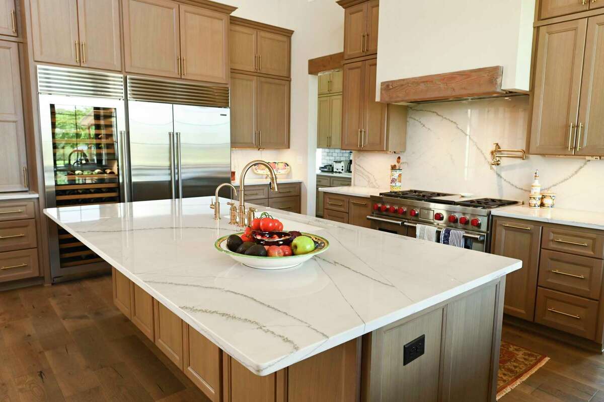 The kitchen has countertops and a backsplash of white quartzite shot through with gray streaks.